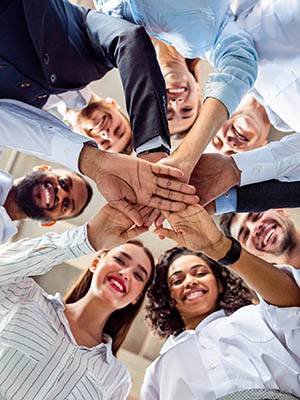 Diverse team of professionals joining hands together representing City Property's collaborative workplace culture and HOA management careers in Phoenix, AZ