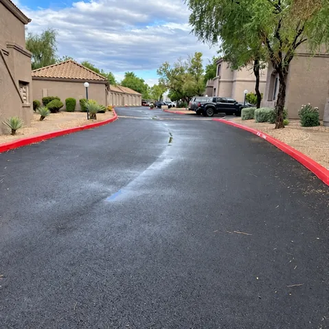 Fully reconstructed private street at Talavera HOA lined with red curbs, desert landscaping, and residential buildings